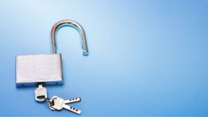 Shiny silver padlock with keys on a light blue background, symbolizing security and protection for your home or valuables.