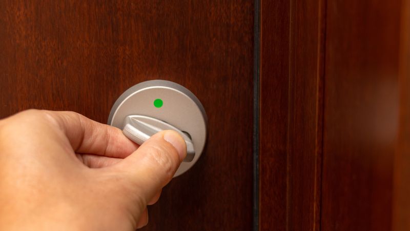 Smart lock being operated on a wooden door, showcasing modern home security technology.