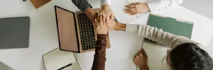 Team of professionals collaborating over a laptop and documents, emphasizing teamwork and security solutions related to ANLI LOCK products.